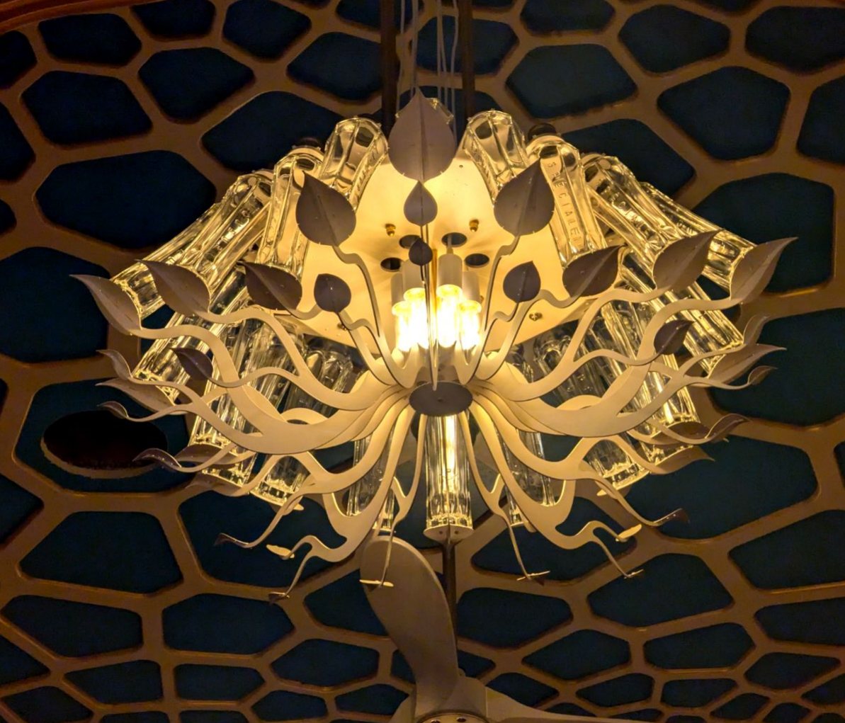 Glass and metal lotus chandelier against a cellular ceiling pattern