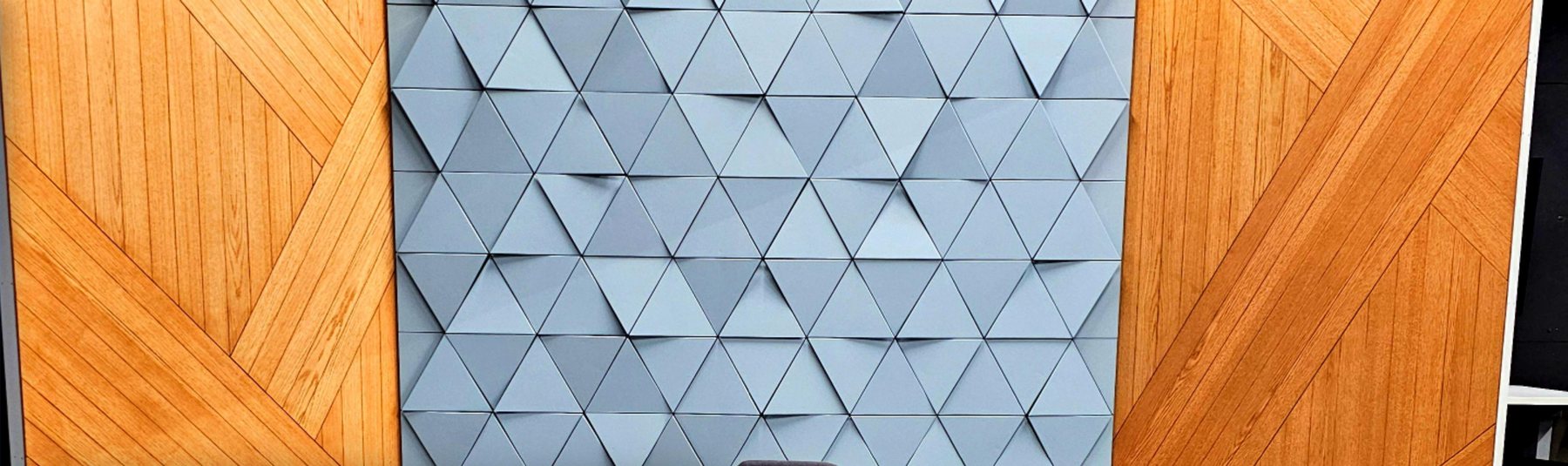 Studio set with a pale geometric triangle wall between angled wood panels