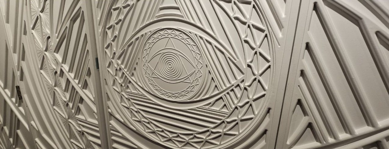 The quiet white side of the divider with a carved eye motif